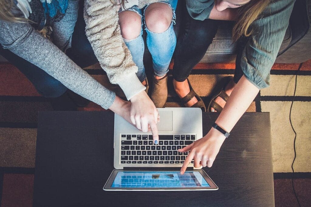 Two students working on a laptop